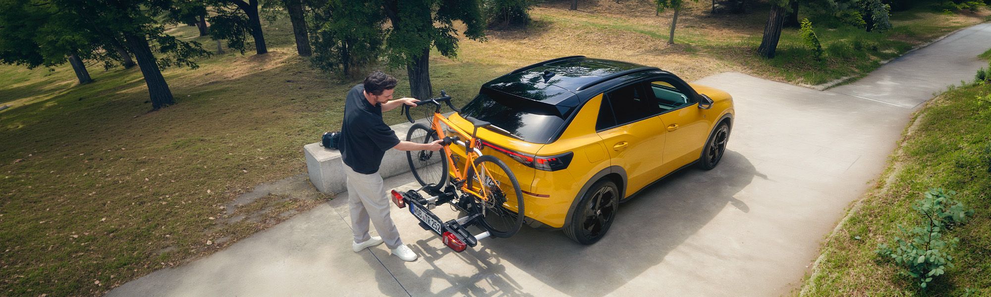 Servicemitarbeiter mit Tablet vor einem Volkswagen Autohaus mit geparkten Fahrzeugen.